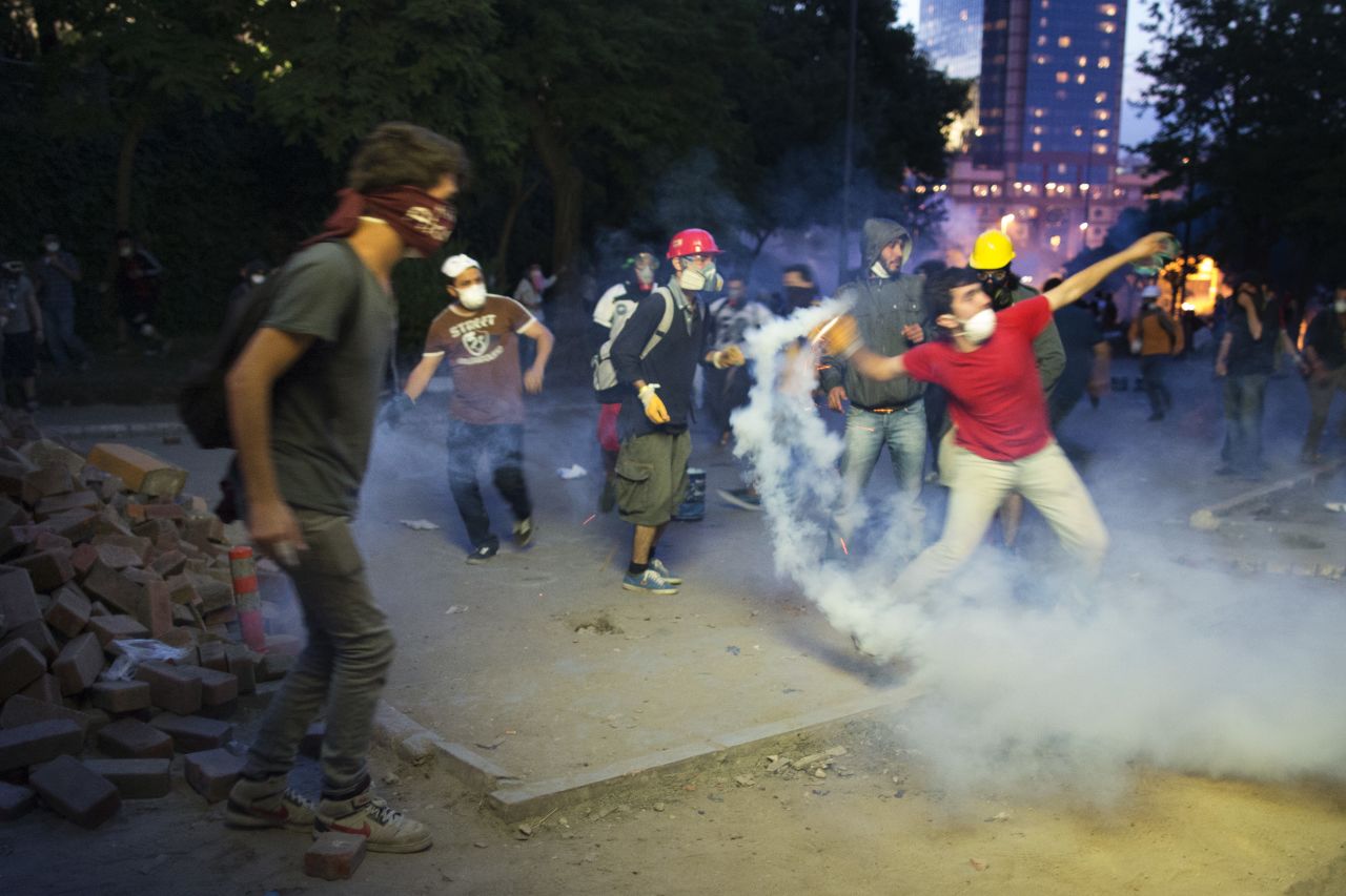 Protesters throw riot police's tear gas back at them in Istanbul on June 3.