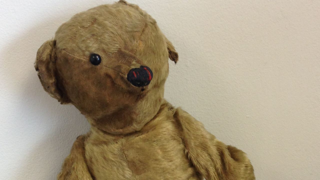 The bear and the old photograph were left in Bristol Airport's departure lounge more than 14 months ago.