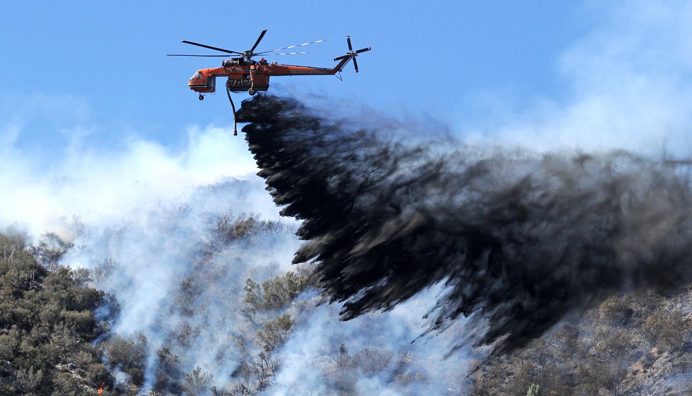 A helicopter drops fire retardant on a flareup of the Powerhouse Fire near Lake Hughes, California, on Monday, June 3. More than 2,000 firefighters are battling the blaze, which started on May 30 and has spread to more than 30,000 acres about 70 miles north of Los Angeles.