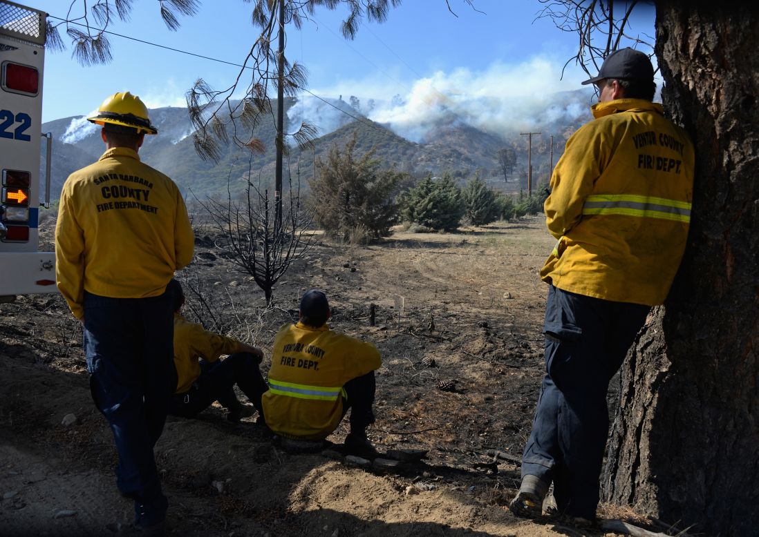 Firefighters watch a hillside burn near Lake Hughes on June 3.