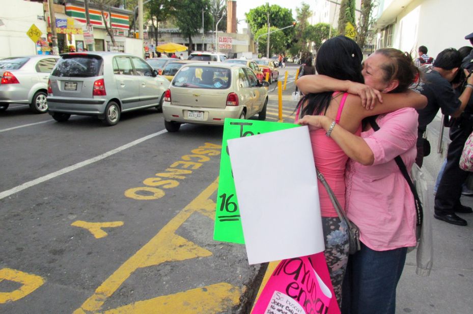 Family members of Jerzy Ortiz Ponce embrace one another while holding signs for the missing on May 31 in Mexico City.
