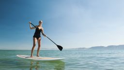 USA, Utah, Garden City, young woman standing on paddleboard