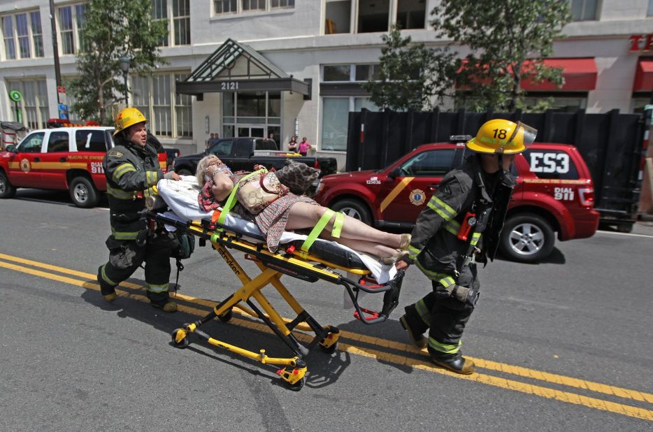 An injured woman is taken to an ambulance after the building collapse.
