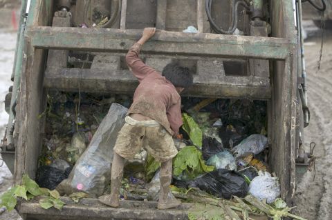 A child picks through garbage instead of going to school. Many families depend on the money the children make at the dump, about $10 a month, according to Bill Smith.