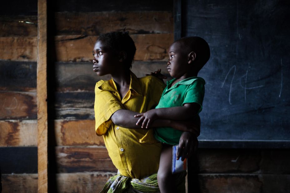 A displaced Congolese girl holds a child in a classroom used for shelter in the village of Kibati, on the outskirts of Goma.