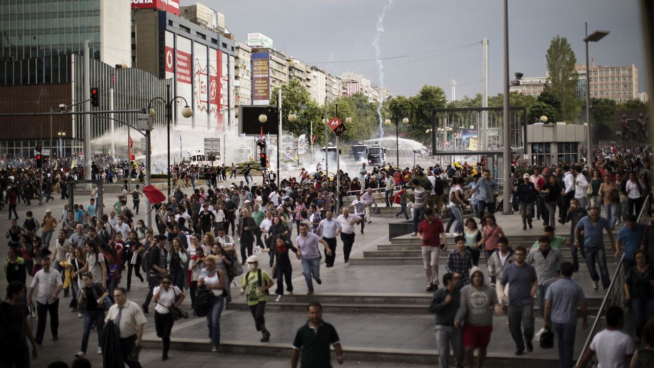 Demonstrators run for cover as police use water cannons and tear gas on the crowd in Ankara on June 5.