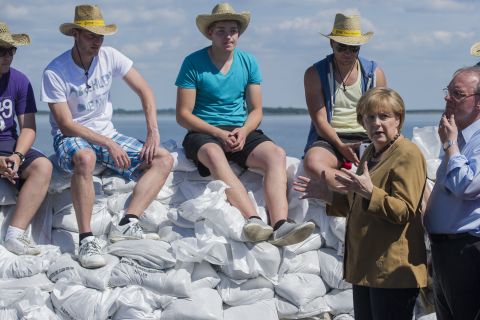 German Chancellor Angela Merkel and Reiner Haseloff, right, premier of the German state of Saxony-Anhalt, speak with volunteers about building a sandbag barrier near Lake Goitzsche in Bitterfeld-Wolfen, Germany, on June 6.