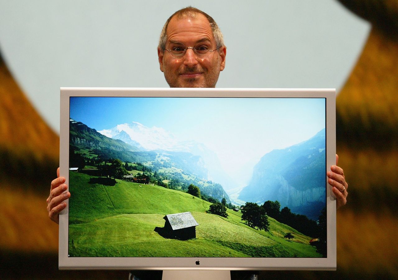 Jobs posed here with a new flat-panel display, the first 30-inch model designed for the personal computer. He also announced the 2005 release of OSX Tiger.