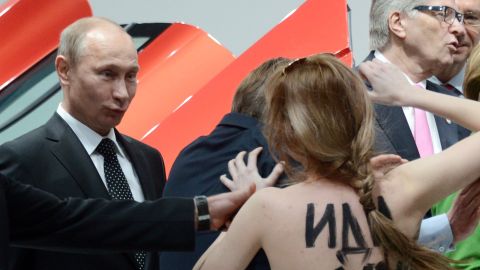 A topless protester shouts at Putin and German Chancellor Angela Merkel during a visit to the Hanover Industrial Fair in central Germany in April 2013. Human rights groups say civil liberties and democratic freedoms have suffered during Putin's rule.