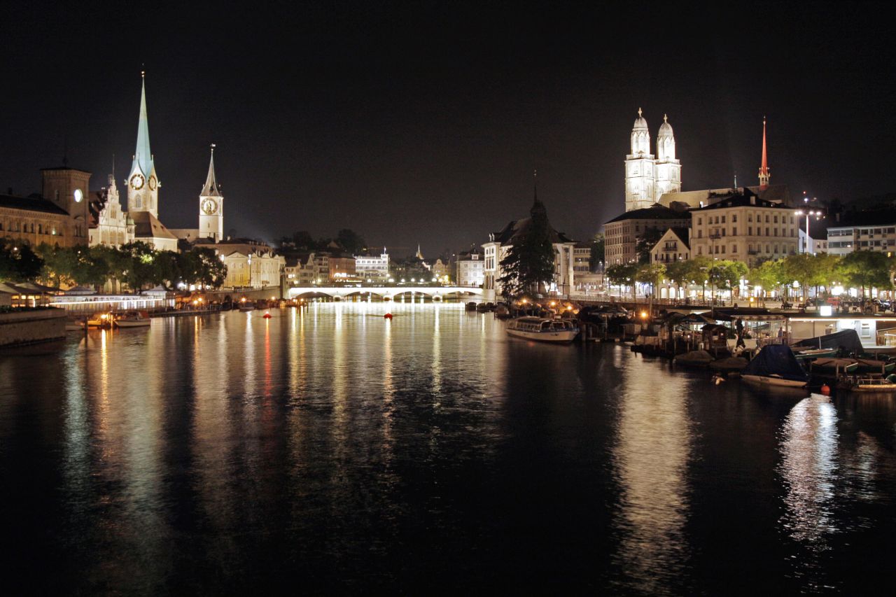 Zurich, Switzerland's largest city, rose two notches in the 2013 ECA survey to be the world's seventh most expensive city to live as an expat. In this photo, a night view of the old town of Zurich with the Grossmuenster church (R) right and left of the Limmat river.