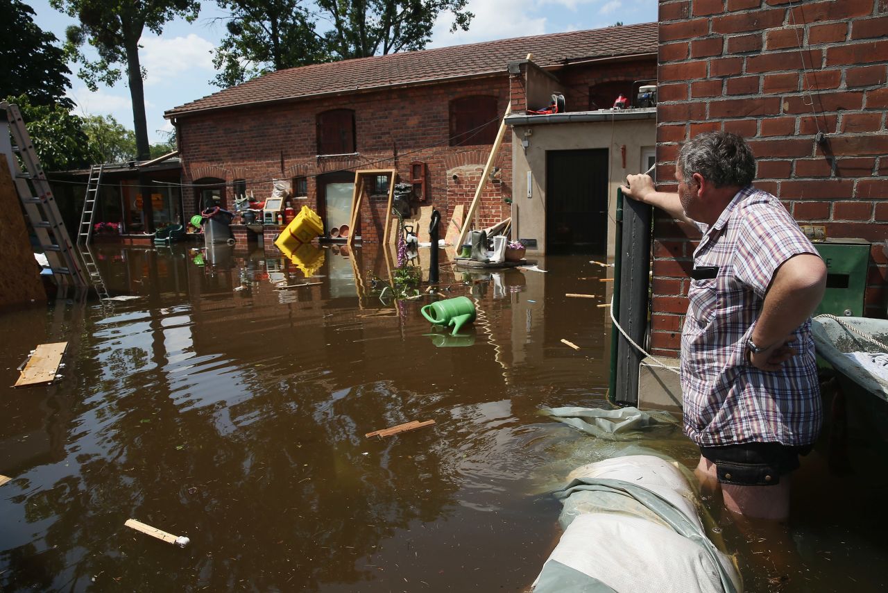 A resident wades to a neighbor's house on a flooded street near the swollen Elbe River on Friday, June 7, in Elster, Germany.