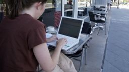 A woman uses free Google WiFi while sitting outside of a cafe August 16, 2006 in Mountain View, California. 