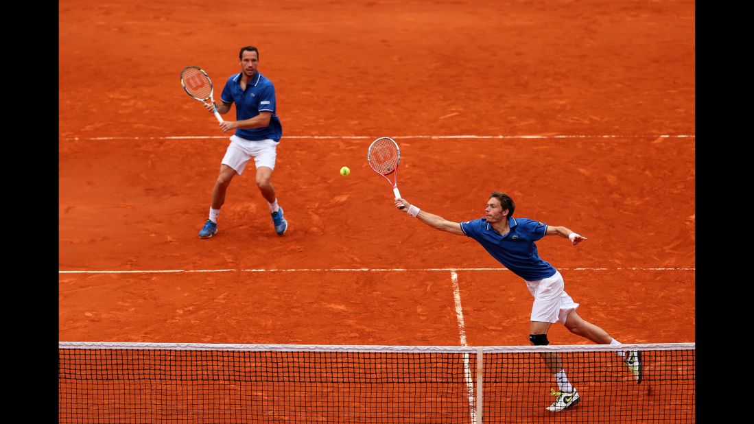 Mahut plays a forehand as his partner Llorda stands ready in the men's doubles final match.