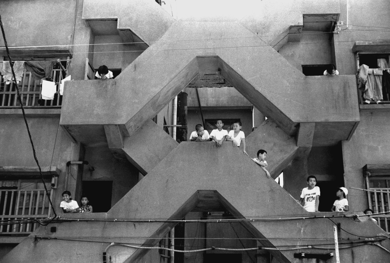 Archive photograph from the 1960s shows children playing in the stairways of the apartment blocks. At that time the population density on the island was among the highest in the world.