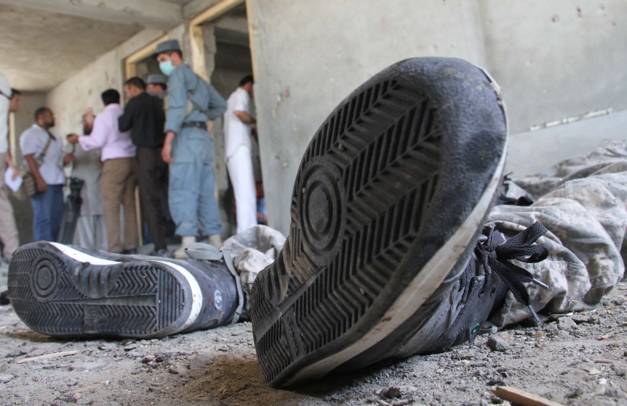 Afghan security officials inspect the body of a Taliban militant on June 10.