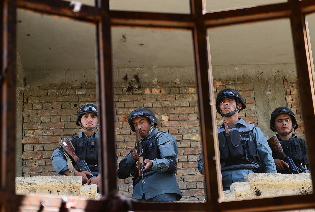 Afghanistan police stand guard in a building that was used for the June 10 attack near the Kabul airport.