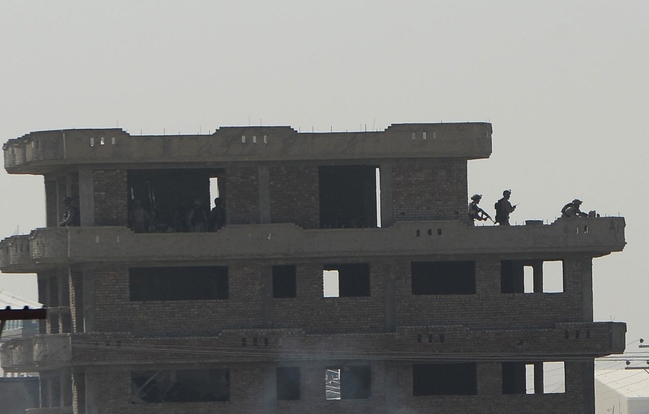 Members of the Afghan Crisis Response Unit run on top of a roof during the June 10 clash with Taliban fighters.