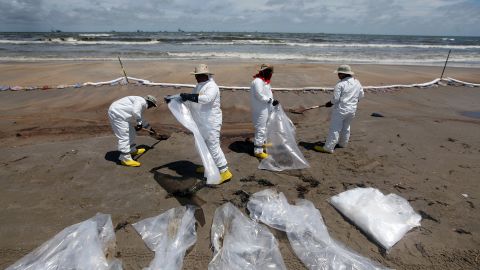 Workers in June 2010 clean up on Fourchon Beach in Louisiana after the Deepwater Horizon spill.