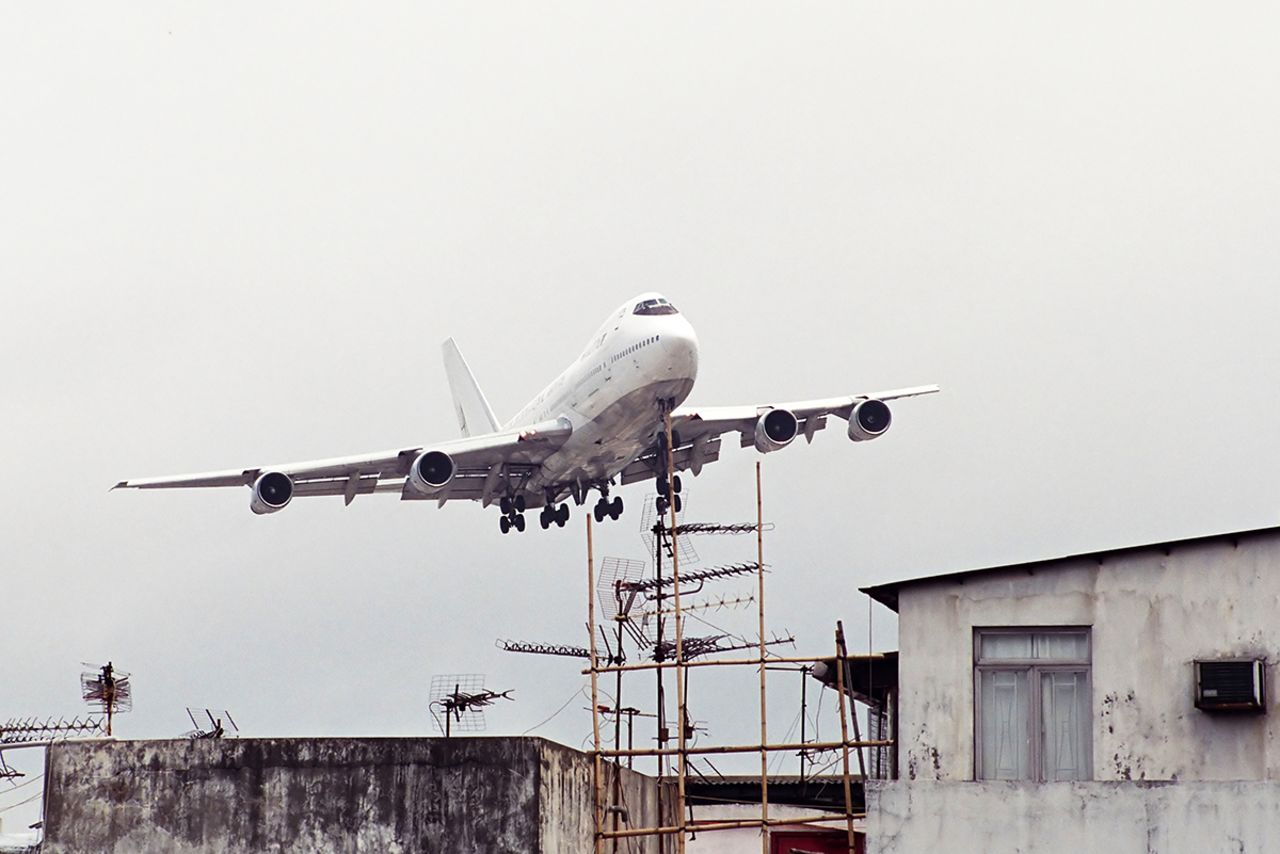 <strong>Only at Kai Tak: </strong>A passenger jet flies above bamboo scaffolding and TV antennae. 