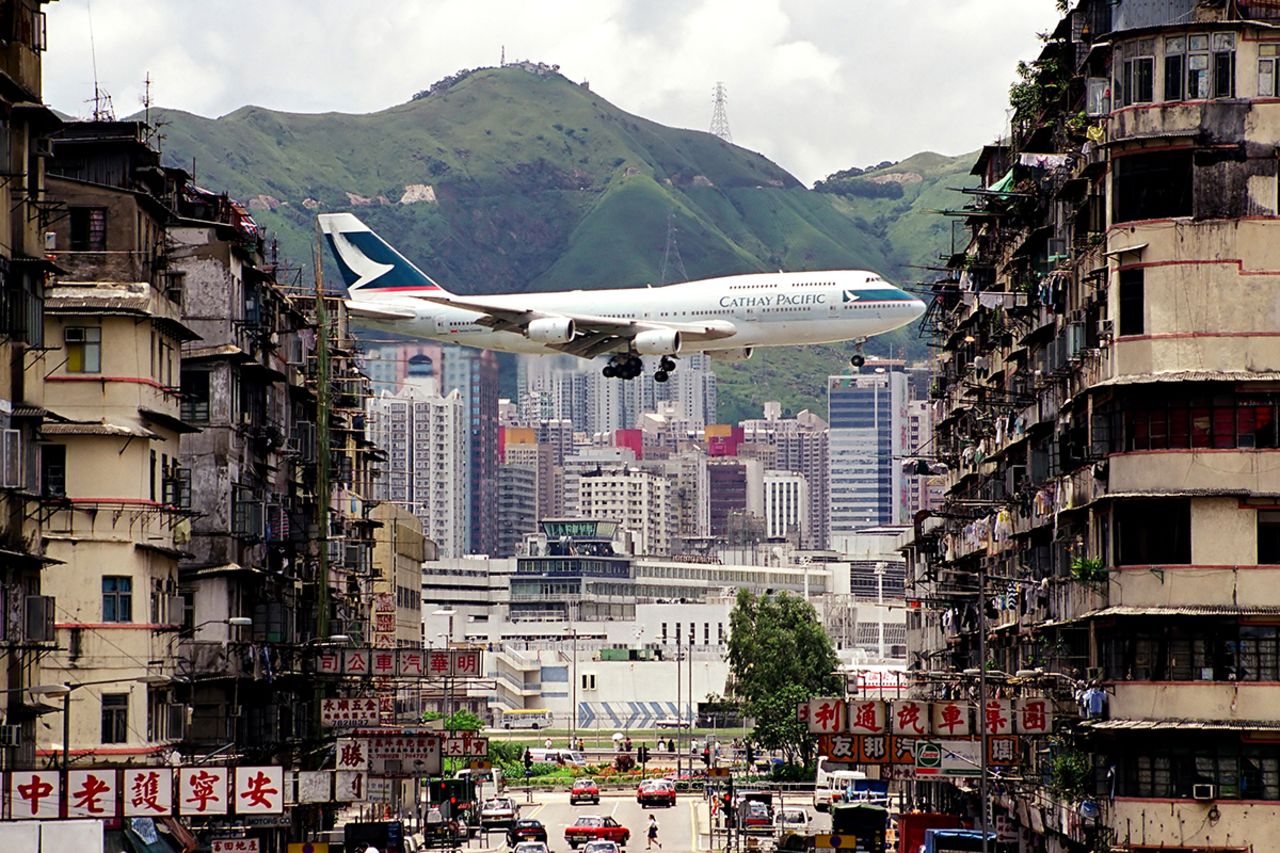An iconic shot of Kai Tak International Airport, Hong Kong --a departing Cathay Pacific's flight captured in between the walk-up buildings in Kowloon City. The airport was replaced by Chek Lap Kok airport in 1998.