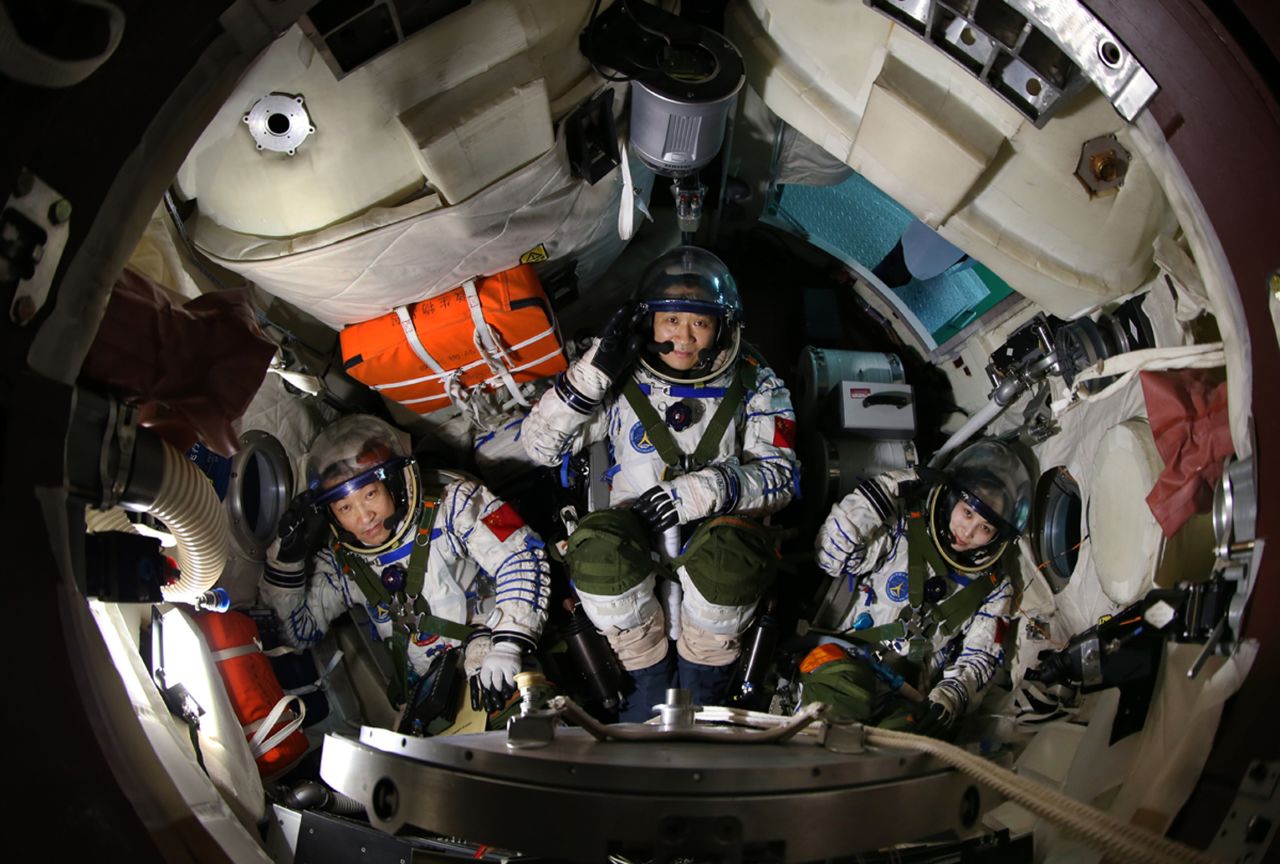 Xiaoguang, left, Haisheng and Yaping sit in a simulated spaceship capsule on April 29.