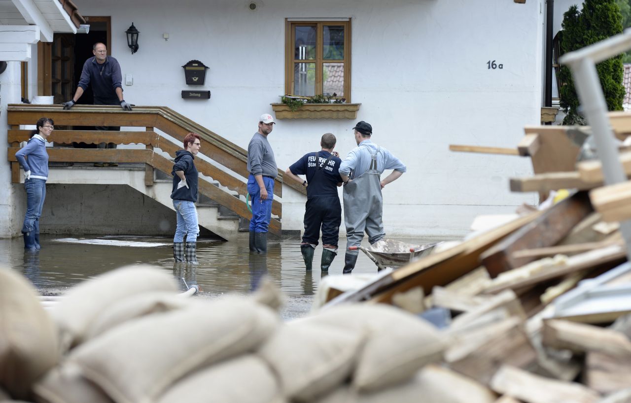 Residents stand in front of a house that was hit by floodwaters from the Danube River in Fischerdorf, Germany, on Tuesday, June 11.