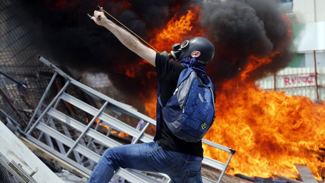A protester uses a slingshot to throw stones at riot police on June 11.