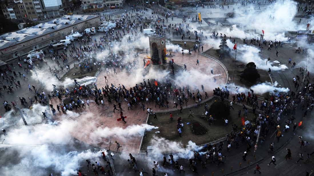 People flee as riot police fire tear gas on Taksim Square on June 11.