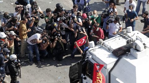 Photographers crowd around a protester posing in front of a riot police vehicle at Taksim Square on June 11.