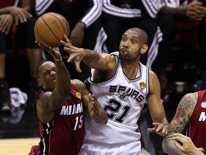 Mario Chalmers of the Miami Heat goes up for a shot against Tim Duncan of the San Antonio Spurs in the first half.