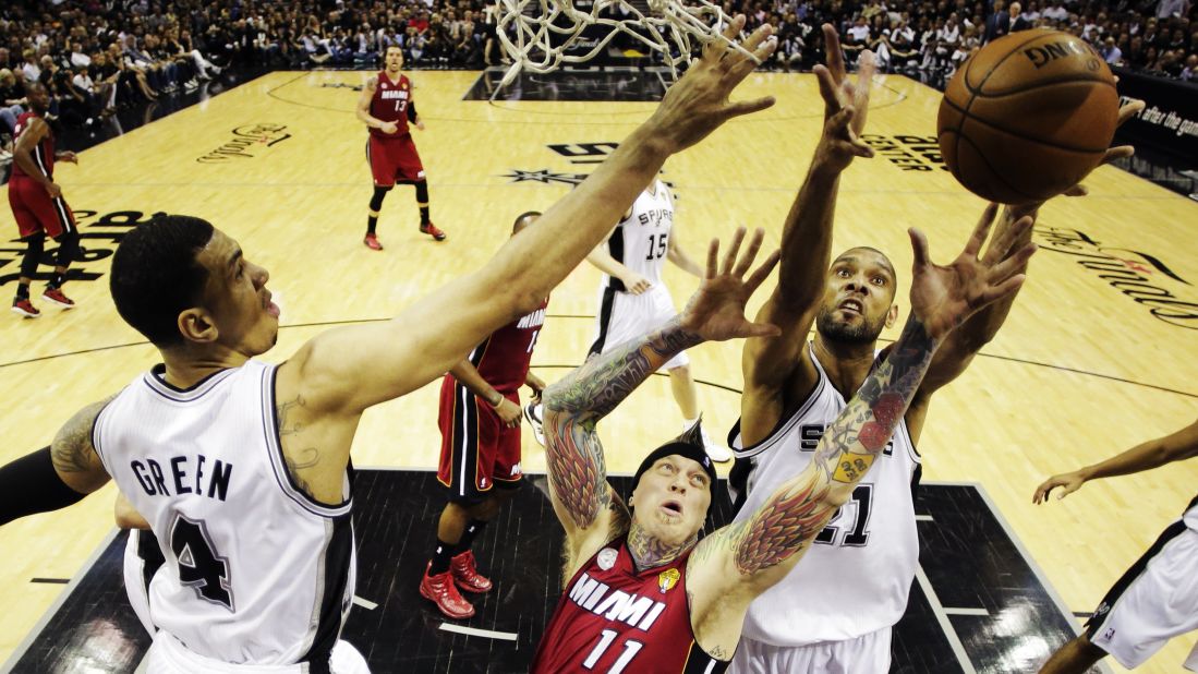 Miami's Chris Andersen goes for a rebound against the San Antonio Spurs' Tim Duncan, right, and Danny Green, left.