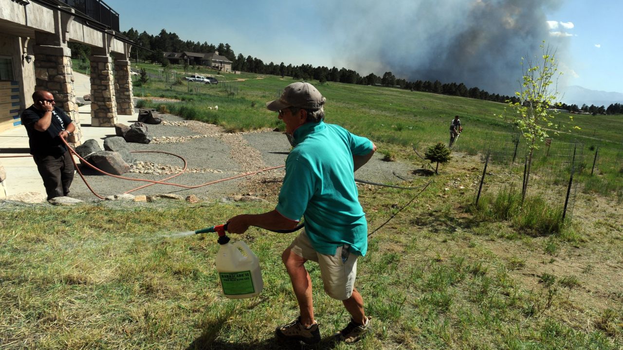 Lynd Fitzgerald sprays fire retardant around a house in Colorado Springs on June 11.