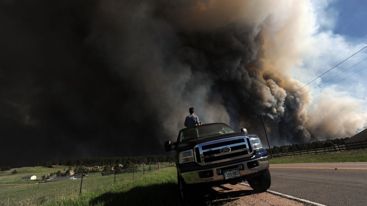 Andrew Dunlap and his father, Dave Dunlap, watch as a wildfire burns behind their house in Colorado Springs on June 11.