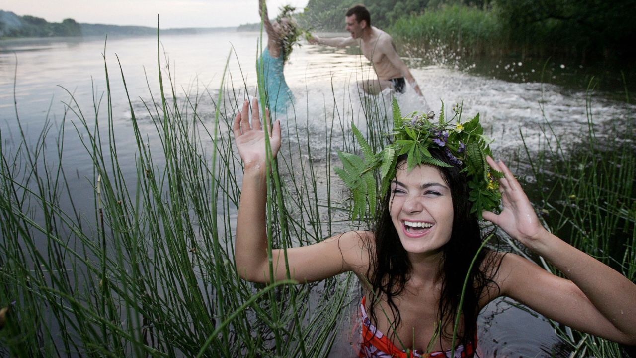 BELARUS: People bathe in the lake of Vyacha during 'Ivan Kupala Day', a traditional Slavonic holiday celebration in Mochany village, 25 km outside Minsk, early 07 July 2006. During the celebration originating from pagan times, people plait wreaths, jump over fires and bathe. 