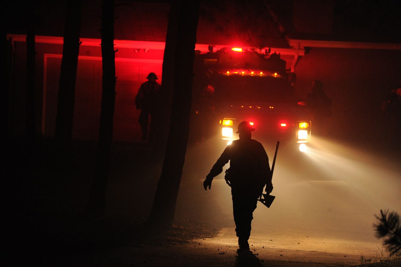Firefighters from the Black Forest Fire Department race toward a burning home near Colorado Springs on June 11.