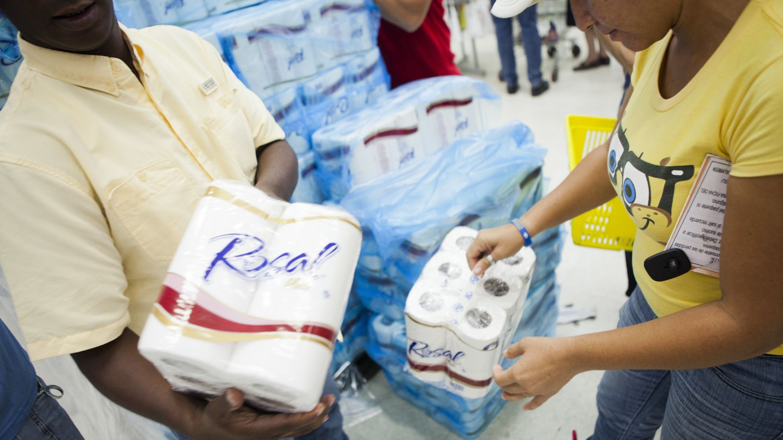 File photo of consumers buying rationed goods during the inauguration of the state-owned Bicentenario supermarket in Caracas in June.