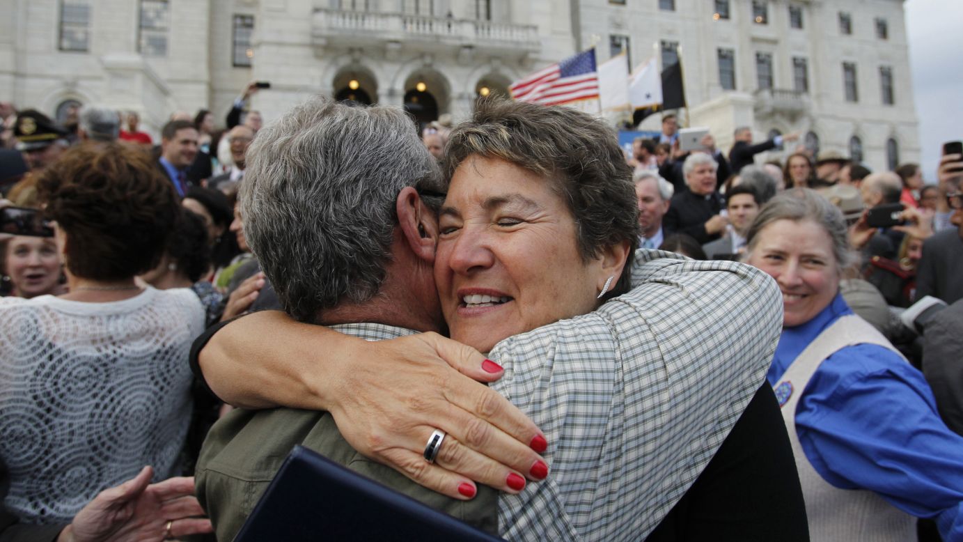 Rhode Island state Sen. Donna Nesselbush, right, embraces a supporter after the Marriage Equality Act was signed into law at the statehouse in Providence on May 2, 2013.