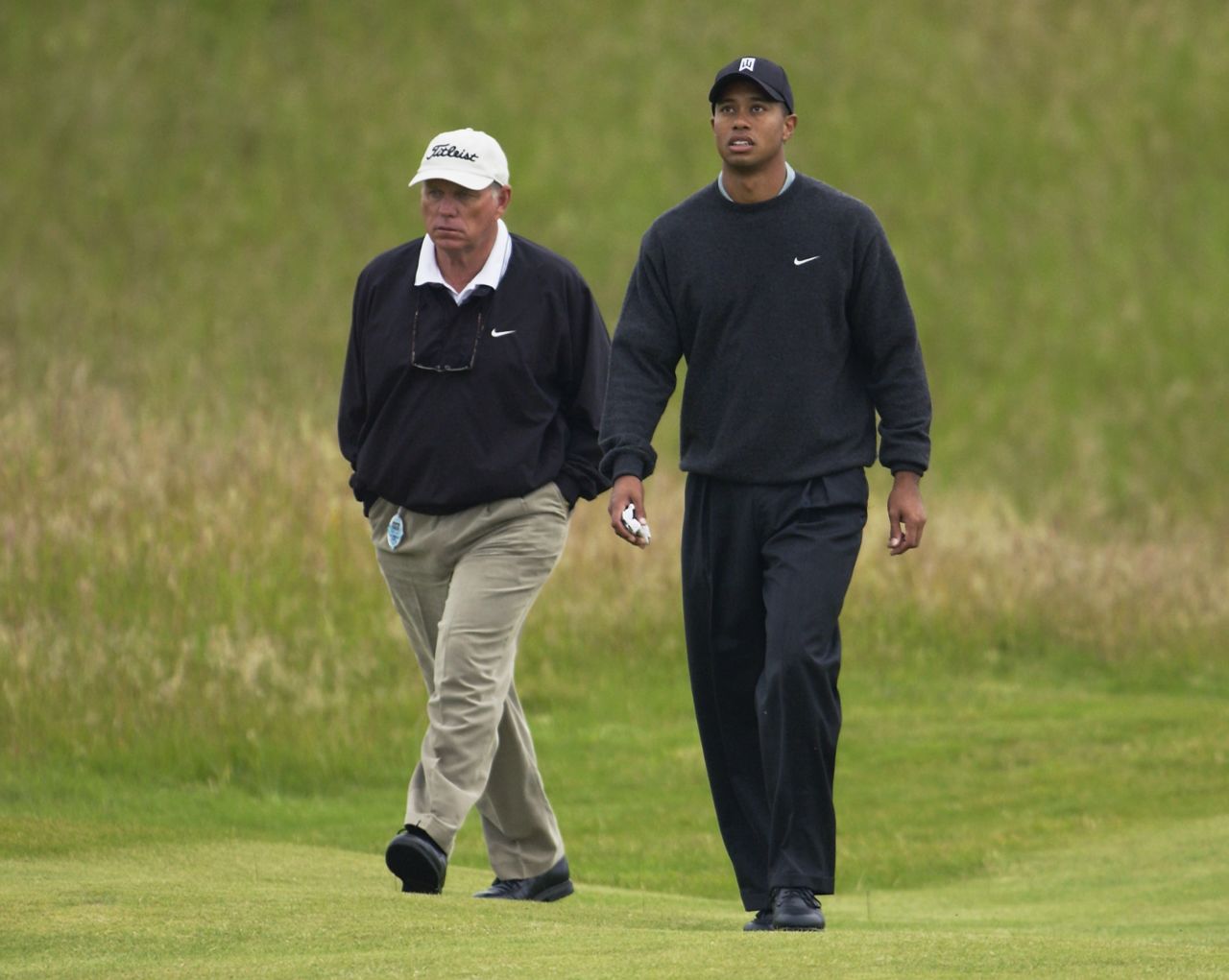 Butch Harmon walks the course with Woods at the British Open in 2002. Harmon turned professional in 1965 and won one event on the PGA Tour before becoming a coach, helping Tiger to the first eight of his 14 major wins.