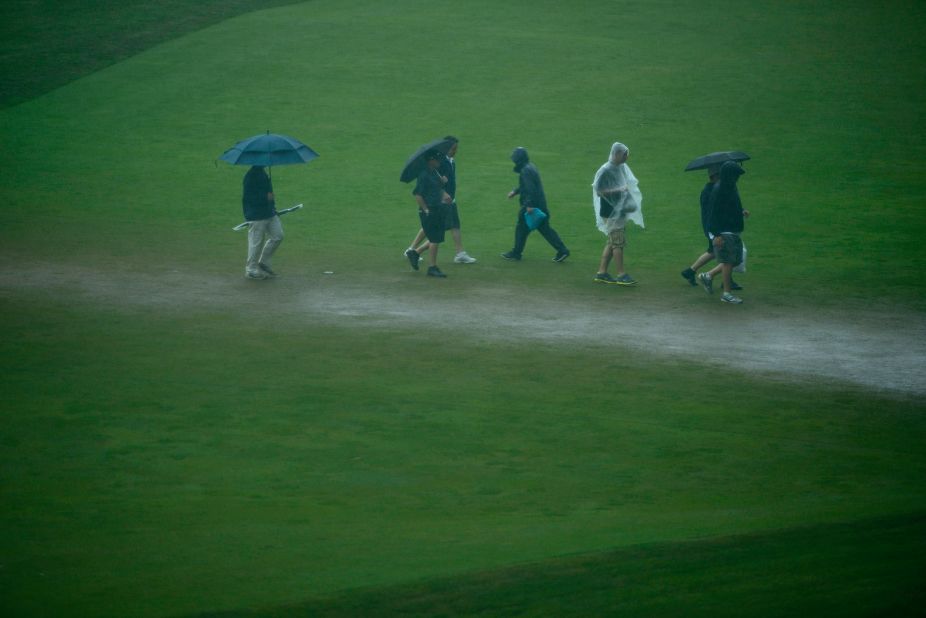 People traverse the 18th fairway during a weather delay on June 13.