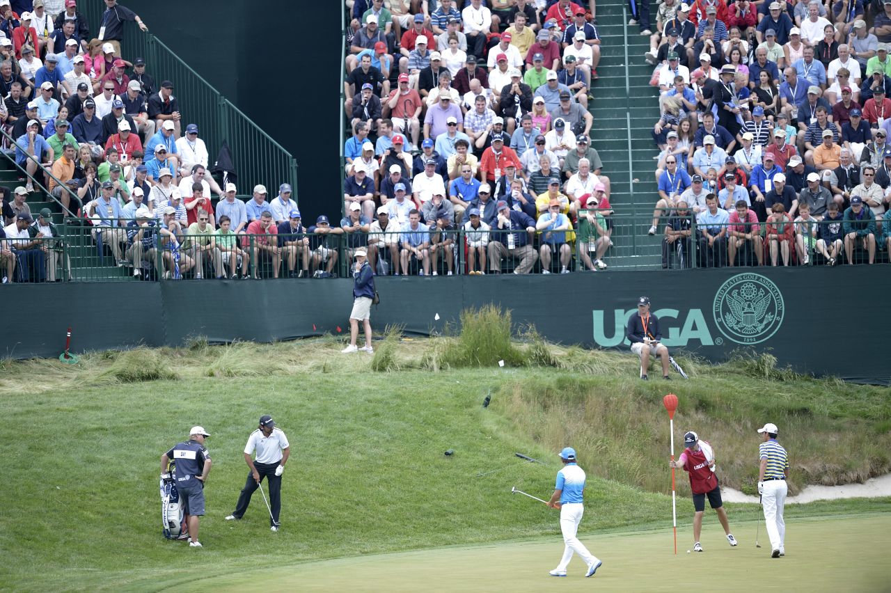 Jason Day of Australia, Rickie Fowler of the United States and Matteo Manassero of Italy play on the 17th green on June 13.