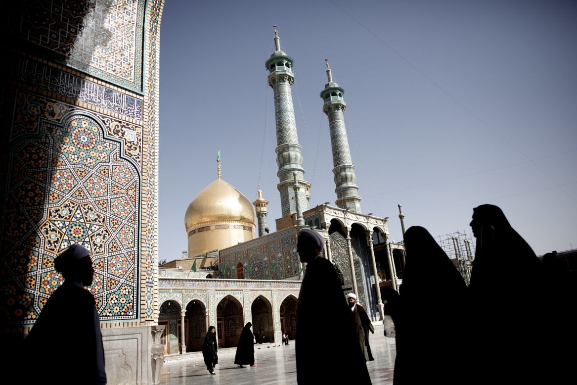 Pilgrims and clergymen walk across the courtyard of the Masoumeh holy shrine in the religious Shiite Muslim city of Qom on Sunday, June 9. Iran's powerful bazaar merchants and Shiite clergy spearheaded the 1979 Islamic revolution, but their role in the country's political scene has waned over the years, analysts say.