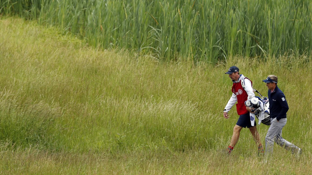 Luke Donald of England walks with caddie John McLaren on the 17th hole on June 14.
