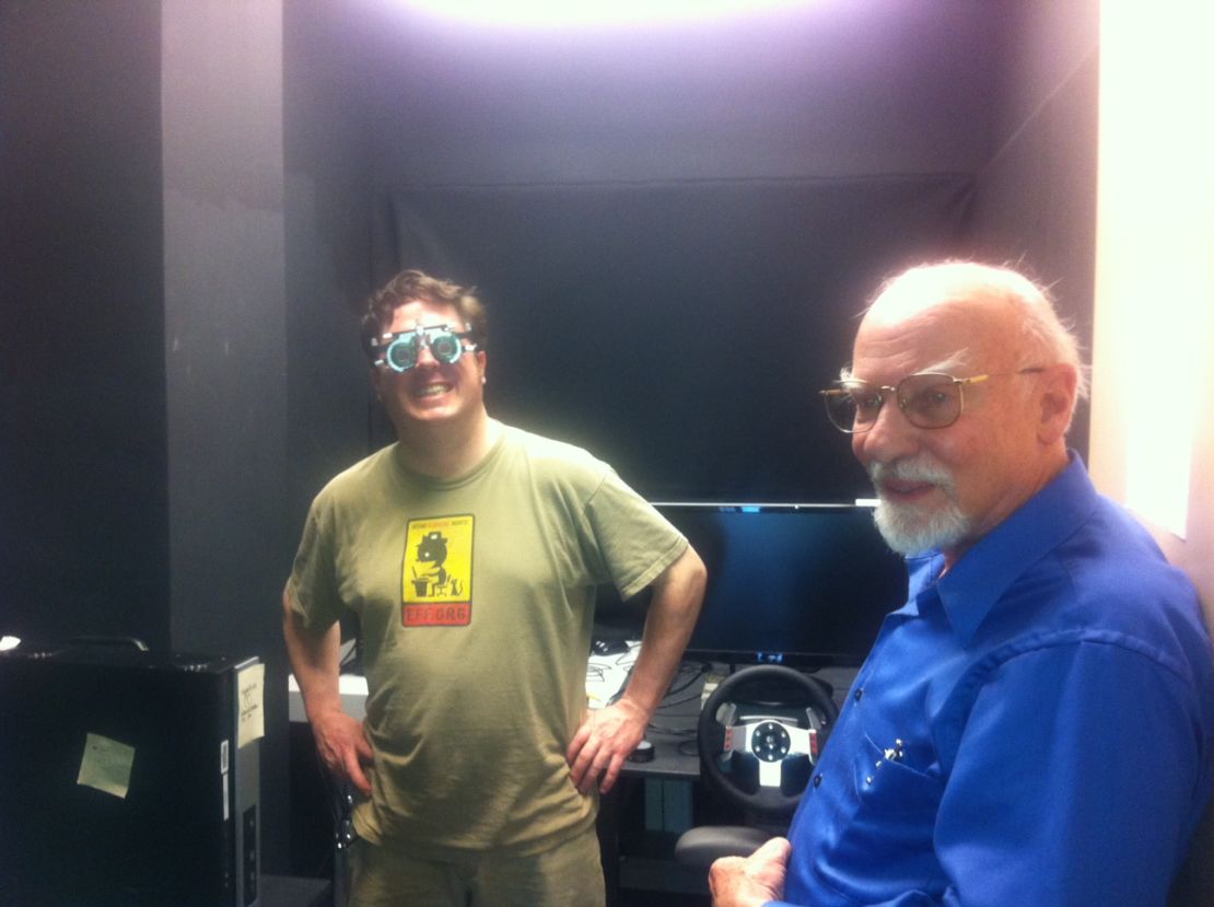 Paul Sosbee, left, tries out a driving simulator that Bruce Bridgeman is studying.