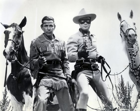 The Lone Ranger, played by Clayton Moore, right, and his Native American partner, Tonto, played by Jay Silverheels, pose with their trusty steeds.