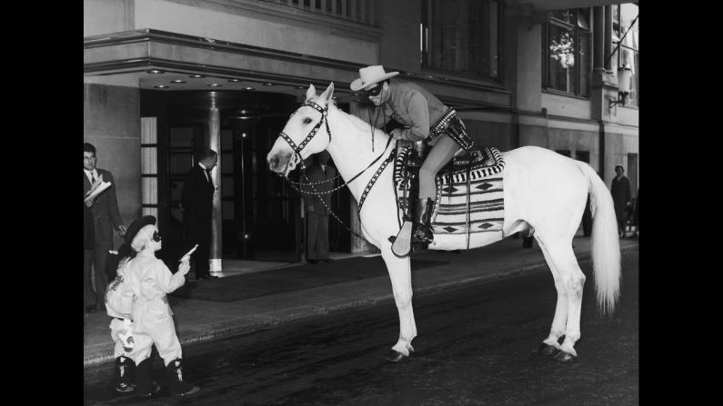 Outside the Savoy Hotel in London, two small boys hold up the Lone Ranger on July 21, 1958. Clayton Moore was in London for a four-week promotional tour, and the boys were  members of the Lone Ranger Club.