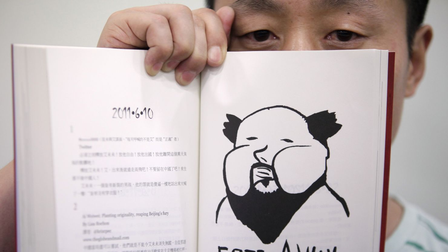 Author Du Bin poses with his book "God Ai," said to be the first biography of dissident artist Ai Weiwei.