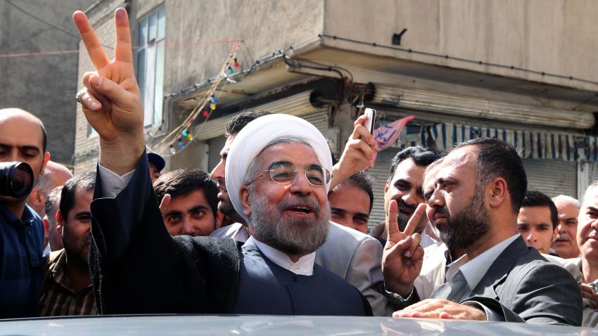 Iranian presidential candidate, Hassan Rouhani flashes a victory sign as he leaves a polling station after voting in Tehran on June 14, 2013.