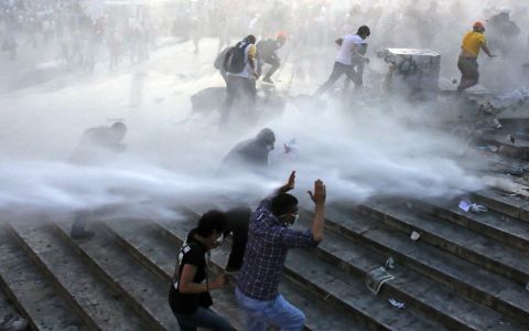 Protesters run for cover as riot police spray them with a water cannon on June 15. 