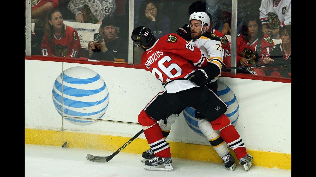 The Blackhawks' Michal Handzus checks Andrew Ference of the Boston Bruins.