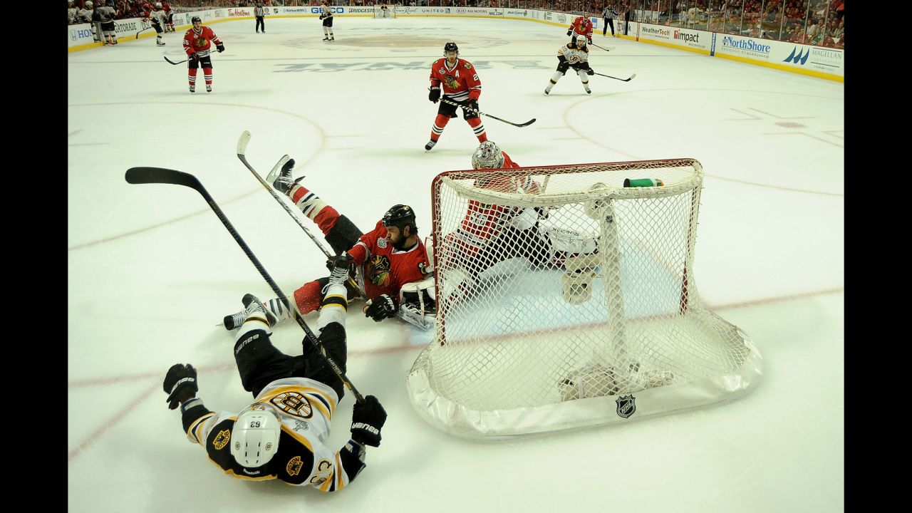 Brad Marchand of the Boston Bruins falls to the ice as Corey Crawford of the Chicago Blackhawks tends goal.